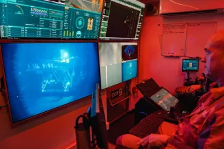 technicien watches the mining machine on the seabed